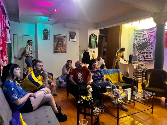 Ukraine fans watch the national team's group match against Slovakia in the 2024 Euros at Stunner vintage football shirt shop in Manchester. 