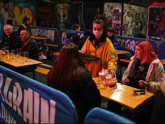 A waitress serving customers in the Northern Quarter. Photo: Oli Scarff/AFP via Getty Images