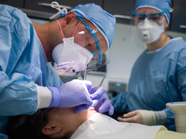 <p>A dentist and a dental nurse carry out a procedure on a patient. Photo: Leon Neal/Getty Images</p>