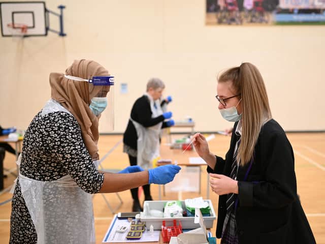 A student handing over a completed lateral flow test. Photo: Oli Scarff/AFP via Getty Images