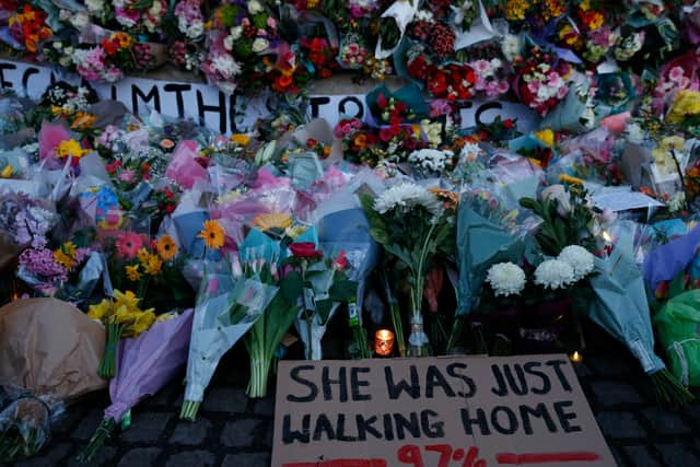 A sign saying “SHE WAS JUST WALKING HOME 97%” among the flowers and candles on Clapham Common for Sarah Everard. Photo by Hollie Adams/Getty Images 