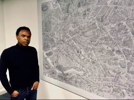 Sketch artist Carl Lavia with the giant drawing of Manchester