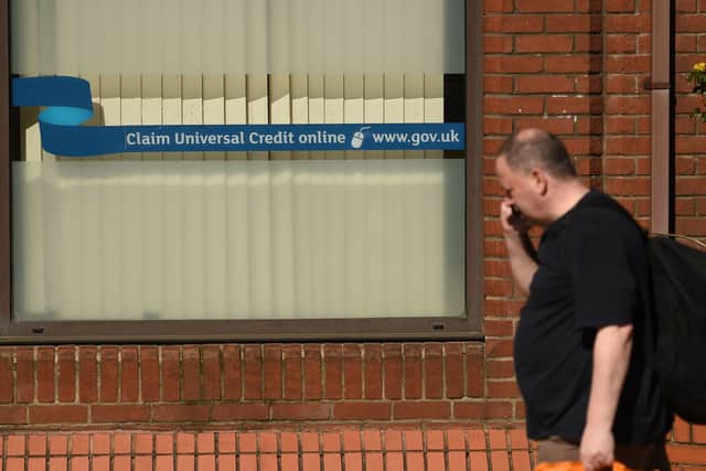 A man walks past a sign for Universal Credit in a Jobcentre Plus office. Photo: Oli Scarff/AFP via Getty Images