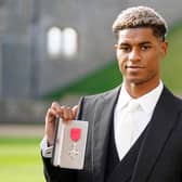 Manchester United and England footballer Marcus Rashford poses with his medal after being appointed a Member of the Order of the British Empire (MBE) for services to Vulnerable Children in the UK during the Covid-19 pandemic, following an investiture ceremony at Windsor Castle in Windsor, west of London on November 9, 2021. (Photo by Andrew Matthews / POOL / AFP) (Photo by ANDREW MATTHEWS/POOL/AFP via Getty Images)