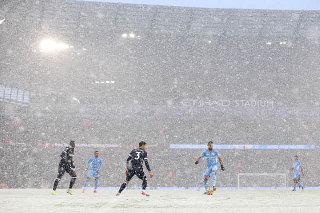 The snow was pelting down at the Etihad. Credit: Getty.