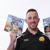 Alex Winstanley with two of his children’s picture books