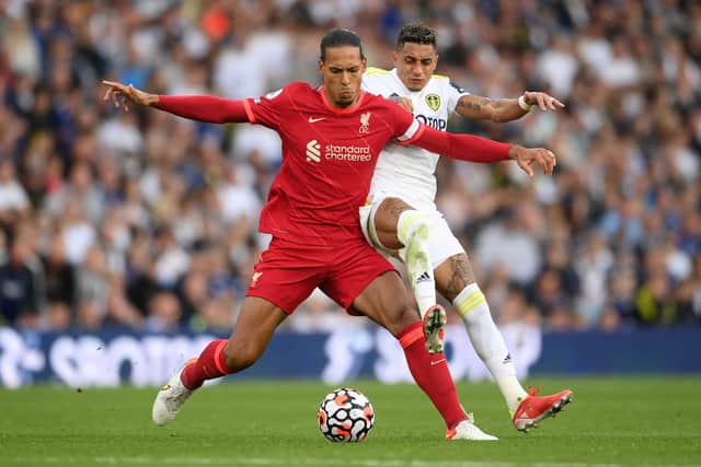Virgil van Dijk of Liverpool is challenged by Raphinha of Leeds United during the Premier League match between Leeds United and Liverpool at Elland Road on September 12, 2021