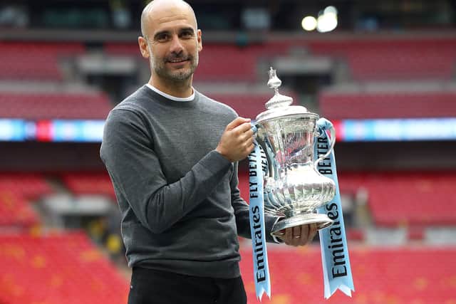 Pep Guardiola with the FA Cup trophy in 2019 Credit: Getty