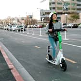 A woman riding an e-scooter. Photo: Transport for Greater Manchester
