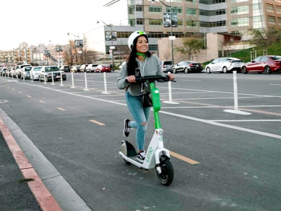 A woman riding an e-scooter. Photo: Transport for Greater Manchester