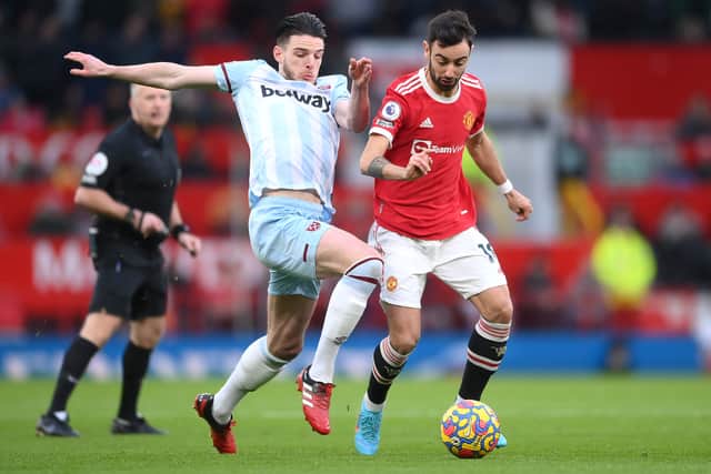 Declan Rice of West Ham United is challenged by Bruno Fernandes of Manchester United during the Premier League match between Manchester United and West Ham United at Old Trafford on January 22, 2022
