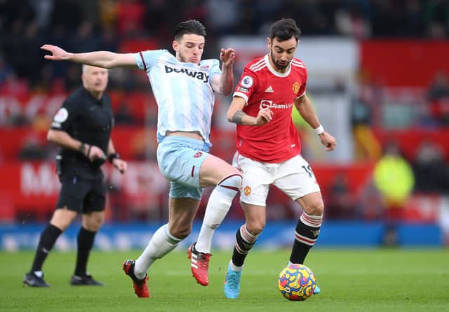 Declan Rice of West Ham United is challenged by Bruno Fernandes of Manchester United during the Premier League match between Manchester United and West Ham United at Old Trafford on January 22, 2022