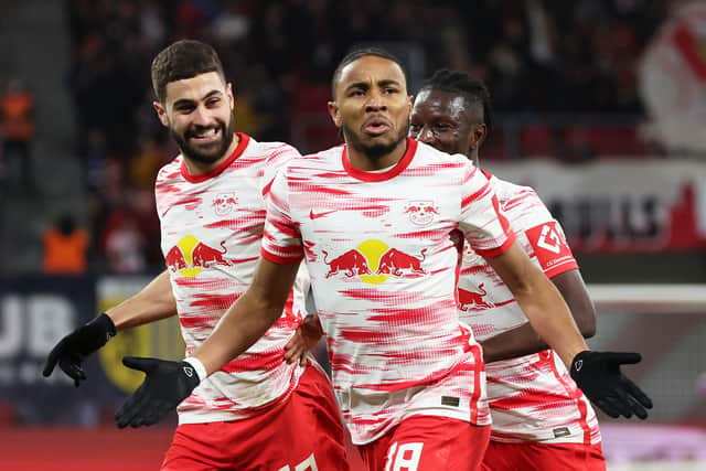 Christopher Nkunku of RB Leipzig celebrates after scoring their sides first goal with team mates Josko Gvardiol and Amadou Haidara during the Bundesliga match between RB Leipzig and 1. FC KÃ¶ln at Red Bull Arena on February 11, 2022 