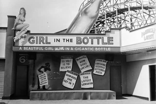 1955:  A fairground booth in Manchester's Belle Vue advertises the 'amazing' phenomenon of the Girl in the Bottle.  (Photo by Peter Purdy/BIPs/Getty Images)