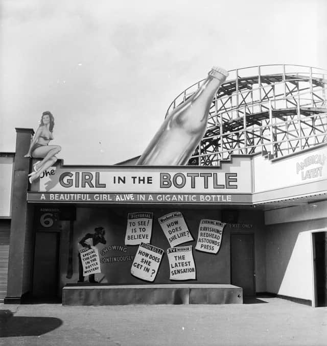 1955:  A fairground booth in Manchester's Belle Vue advertises the 'amazing' phenomenon of the Girl in the Bottle.  (Photo by Peter Purdy/BIPs/Getty Images)