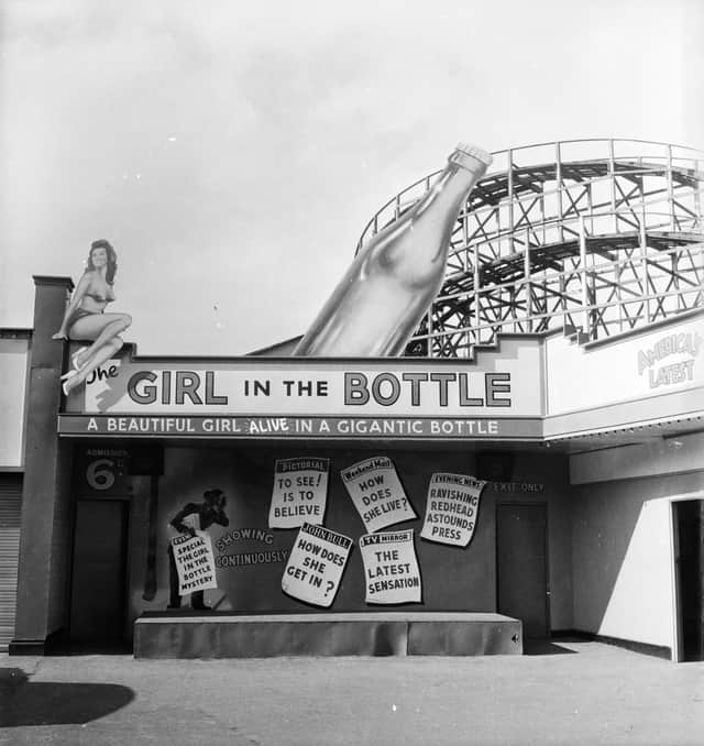 1955: A fairground booth in Manchester's Belle Vue advertises the 'amazing' phenomenon of the Girl in the Bottle. (Photo by Peter Purdy/BIPs/Getty Images)