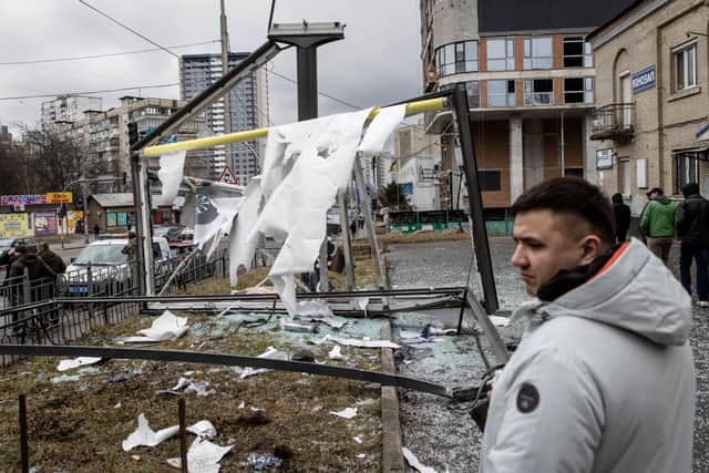 People stand around a damaged structure caused by a rocket on February 24, 2022 in Kyiv, Ukraine Credit: Getty
