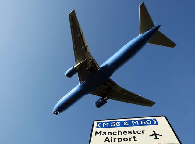A passenger aircraft landing at Manchester International Airport approaches the runway.