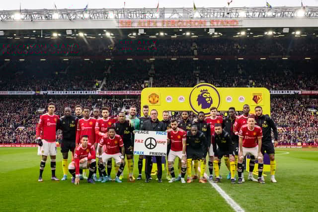 The players stand behind a peace banner at Old Trafford. Credit: Getty.