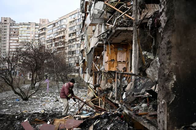 A man clears debris at a damaged residential building at Koshytsa Street, a suburb of the Ukrainian capital Kyiv (Photo: DANIEL LEAL/AFP via Getty Images)