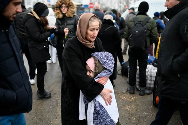 A woman hugs a girl as refugees from Ukraine wait for a transport at the Moldova-Ukrainian border’s checkpoint near the town of Palanca Credit: Getty
