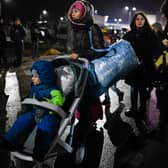 A refugee woman from Ukraine pushes a stroller with a small child after crossing the Moldova-Ukrainian border (Photo: AFP via Getty Images)