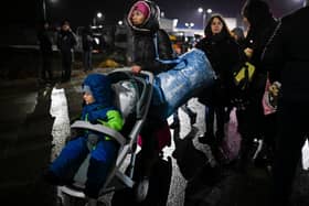 A refugee woman from Ukraine pushes a stroller with a small child after crossing the Moldova-Ukrainian border (Photo: AFP via Getty Images)