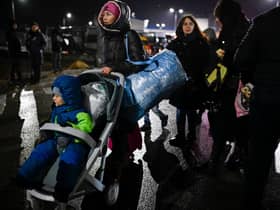 A refugee woman from Ukraine pushes a stroller with a small child after crossing the Moldova-Ukrainian border (Photo: AFP via Getty Images)