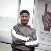 Oldham College student Sinmi Alli-Balogun with his winning poster design on Oldham Central Metrolink stop. Photo: Darren Robinson