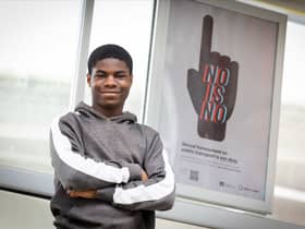 Oldham College student Sinmi Alli-Balogun with his winning poster design on Oldham Central Metrolink stop. Photo: Darren Robinson