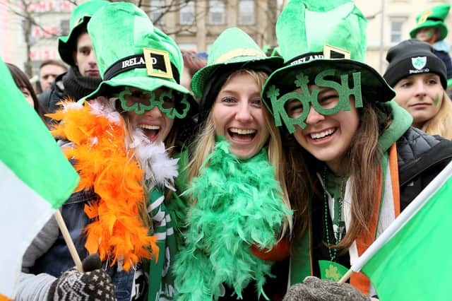 Spectators in fancy dress and face paint line the streets during a St Patrick’s Day parade in 2018 Credit: Getty