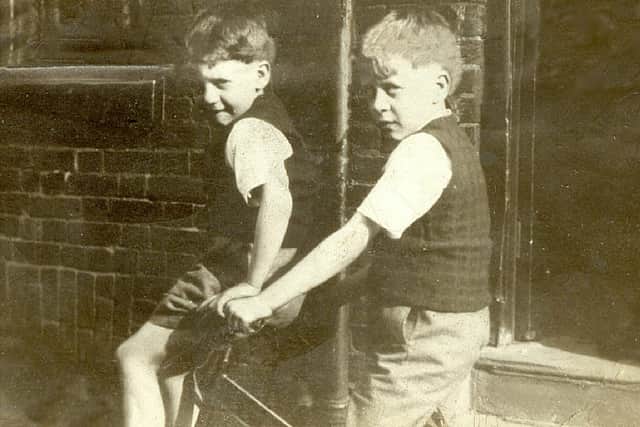 Frank Burton is pictured on the left with his brother Norman as youngsters Credit: family