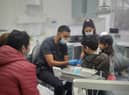 Dr Naveed Patel teaching young refugee children how to use a toothbrush