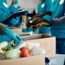 Volunteers packing food and clothes in donation boxes. Photo: AdobeStock