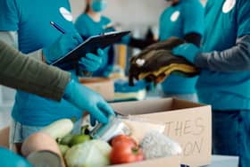 Volunteers packing food and clothes in donation boxes. Photo: AdobeStock