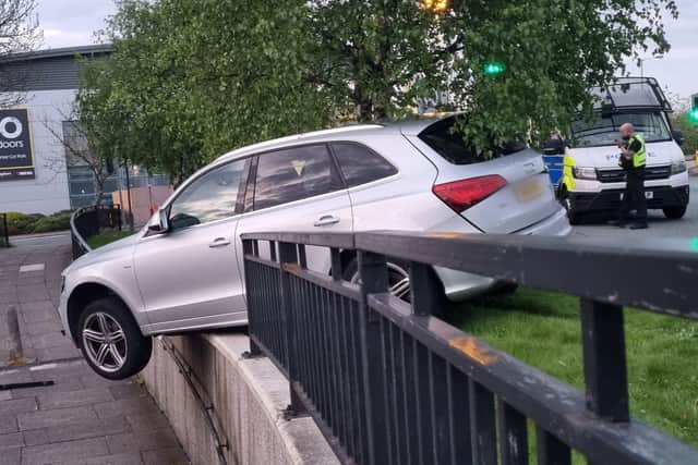 A dramatic photograph shows the silver Audi teetering on a kerb after police tried to pull the driver over on Sunday morning in Bury Credit: Greater Manchester Police / SWNS
