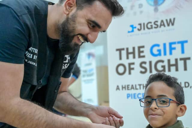 Yousuf helping a child who was fitted with glasses