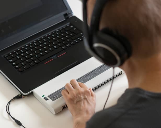 Global Accessibility Awareness Day focuses on digital access and inclusion for people with disabilities or impairments. (Image shows visually impaired person working on computer with assistive technology) 