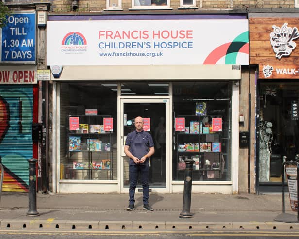 The new Francis House charity shop in Withington with manager Jason Connor standing outside