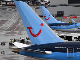 A pilot helped load luggage onto a plane at Manchester Airport.