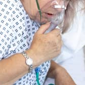 A woman in hospital with breathing difficulties using a respiration mask. Photo: AdobeStock