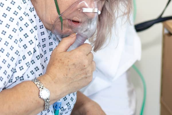 A woman in hospital with breathing difficulties using a respiration mask. Photo: AdobeStock
