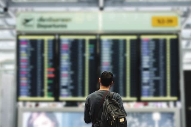 A passenger scrutinises airport information boards. Photo: AdobeStock