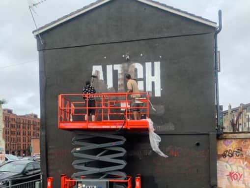 The Aitch advert being removed from the Ian Curtis mural in the Northern Quarter. Photo: Coun Pat Karney
