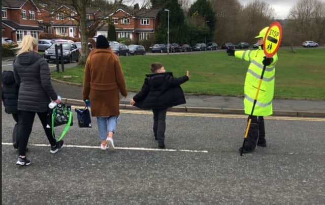 <p>A lollipop man get the thumbs up from a St Vincents Primary School pupil at the Caldershaw Road crossing in Norden Credit: Nick Statham LDR</p>