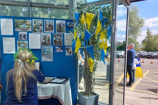 Kateryna Tyshkul arranges a display about the humanitarian aid the community has raised for Ukraine.  Credit: Sofia Fedeczko/Manchester World