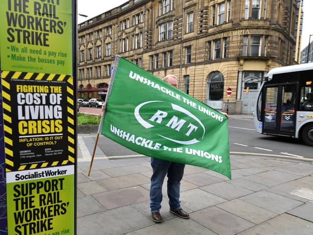 Members of the RMT stand on a picket line outside Manchester Victoria train station during the national rail strike over pay on August 18, 2022