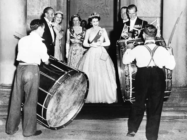 John Warden Brooke, 2nd Viscount Brookeborough (L), Queen Elizabeth II (C) and her husband Prince Philip, Duke of Edinburgh listen to drummers, on July 3, 1953 during their official visit to Northern Ireland.