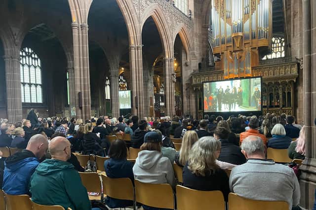 People watch the Queen’s funeral on big screens at Manchester Cathedral