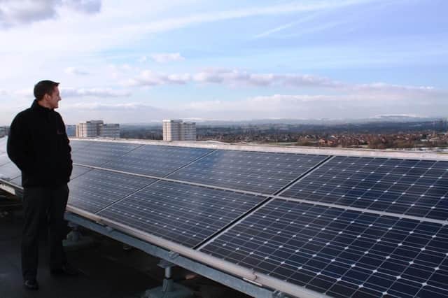 Northwards Home Improvements manager Elliot Simm looking out at North Manchester over solar panels on the roof of Somerton Court. Credit: Northwards.